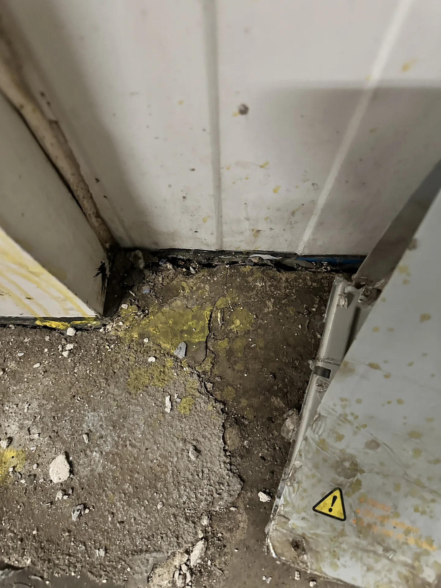 Cracked and deteriorated concrete at a cold storage room perimeter