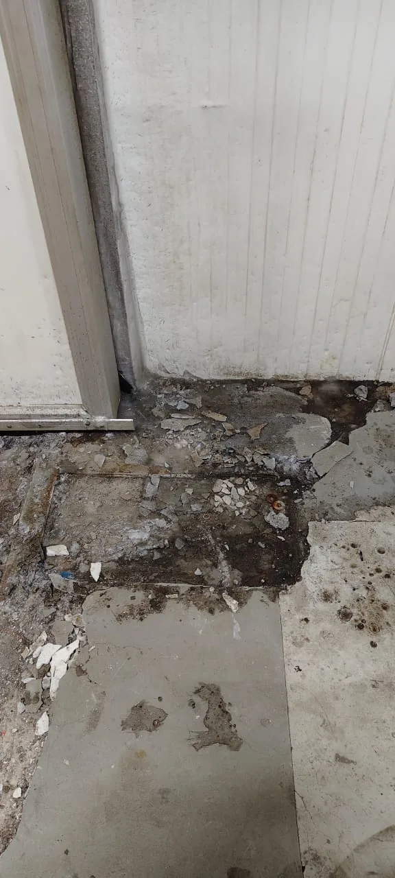Severely deteriorated concrete at a cold storage chamber threshold