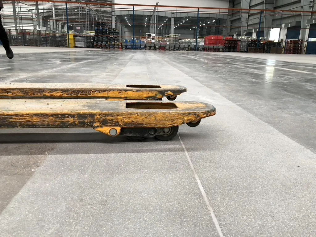 Industrial floor surface beneath pallet-handling equipment